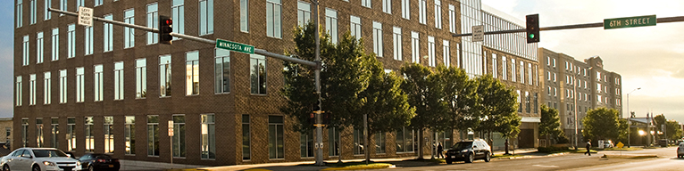 A street corner during the day. It's the junction of 6th street and Minnesota Avenue.